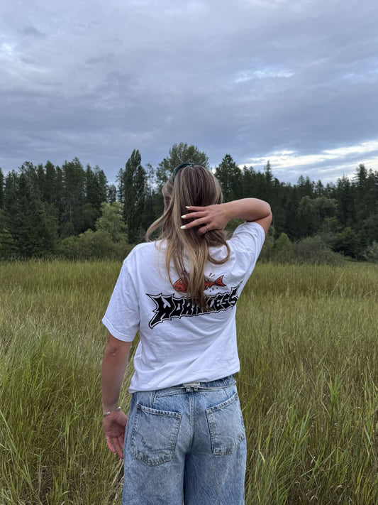 Person wearing a white t shirt in a grassy field size small